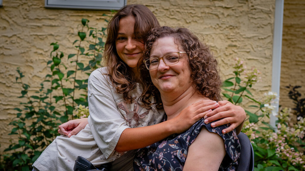 Yvette and her daughter, Lydia, embrace in their backyard.