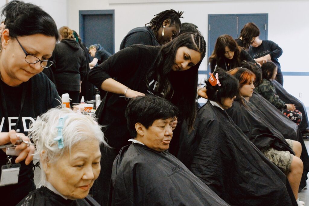 A row of guests relax as their Aveda stylists wash, cut, and style their hair.